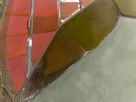 Aerial view of the colorful salt pans in Pomorie featuring geometric pools with vibrant red brown and pale green water separated by narrow paths in Pomorie Burgas Bulgaria. Aerial view of the colorful salt pans in Pomorie featuring geometric pools with vibrant red brown and pale green water separated by narrow paths in Pomorie Burgas Bulgaria.