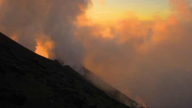 View of Stromboli volcano erupting at sunset Italy.