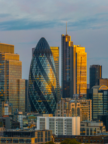 Aerial view of 30 St Mary Axe also known as The Gherkin surrounded by modern skyscrapers and office buildings in the financial district of London England United Kingdom.