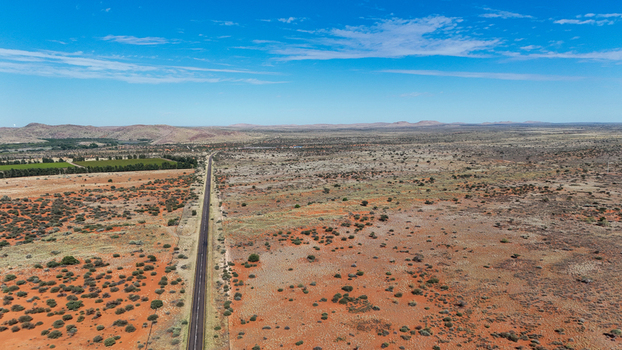 Aerial view of a straight road cutting through the arid landscape with sparse vegetation stretching towards the distant mountains Karoo Desert Northern Cape South Africa. Aerial view of a straight road cutting through the arid landscape with sparse vegetation stretching towards the distant mountains Karoo Desert Northern Cape South Africa.