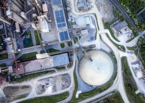 Aerial view of the Irish Cement Ltd industrial facility featuring a large geodesic dome storage silos and solar panels on rooftops in Drogheda County Louth Ireland. Aerial view of the Irish Cement Ltd industrial facility featuring a large geodesic dome storage silos and solar panels on rooftops in Drogheda County Louth Ireland.