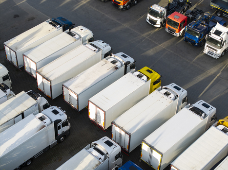 Aerial view of a fleet of semi trucks and trailers parked in an orderly row in a logistics yard in Krakow Lesser Poland Voivode Poland. Aerial view of a fleet of semi trucks and trailers parked in an orderly row in a logistics yard in Krakow Lesser Poland Voivode Poland.