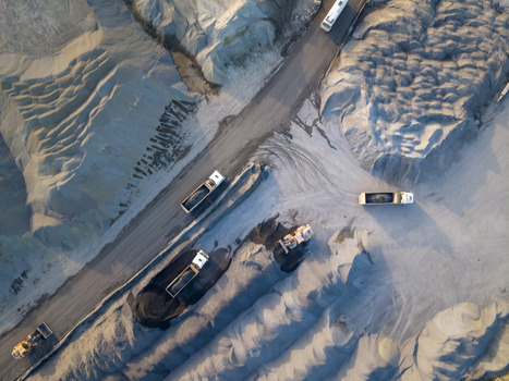 Aerial view of a gravel quarry with heavy trucks transporting materials along dirt roads surrounded by large piles of sand and crushed stone in Istanbul Istanbul Turkiye.