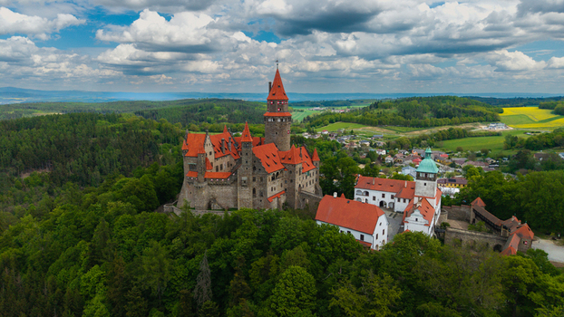 Aerial view of Bouzov Castle with its iconic red tiled roofs and tall stone tower nestled among lush green forests Bouzov Olomoucky kraj Czechia. Aerial view of Bouzov Castle with its iconic red tiled roofs and tall stone tower nestled among lush green forests Bouzov Olomoucky kraj Czechia.