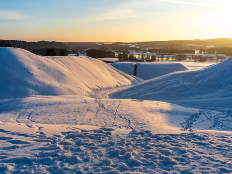 View of the snow covered mounds of the Kernave archaeological site during golden hour in Kernave Vilnius County Lithuania. View of the snow covered mounds of the Kernave archaeological site during golden hour in Kernave Vilnius County Lithuania.