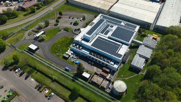 Aerial view of a modern data centre featuring solar panels on the roof surrounded by green lawns and parking facilities in Wellingborough England United Kingdom. Aerial view of a modern data centre featuring solar panels on the roof surrounded by green lawns and parking facilities in Wellingborough England United Kingdom.