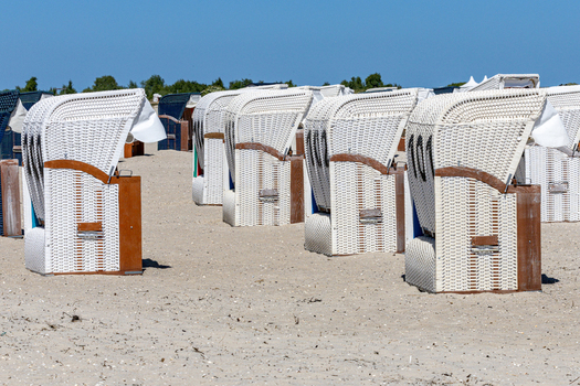 View of Strand Schillig beach chairs on the sand under a clear blue sky in Wangerland Niedersachsen Germany. View of Strand Schillig beach chairs on the sand under a clear blue sky in Wangerland Niedersachsen Germany.