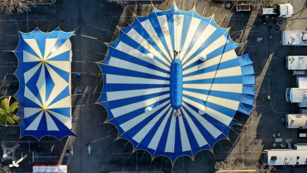 Aerial view of the vibrant blue and white striped circus tents casting long shadows on the asphalt creating a striking geometric pattern on the ground St. Augustine Florida United States. Aerial view of the vibrant blue and white striped circus tents casting long shadows on the asphalt creating a striking geometric pattern on the ground St. Augustine Florida United States.