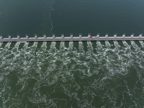 Aerial view of the Eastern Scheldt Storm Surge Barrier with turbulent water flowing through the sluice gates in Vrouwenpolder Zeeland Netherlands. Aerial view of the Eastern Scheldt Storm Surge Barrier with turbulent water flowing through the sluice gates in Vrouwenpolder Zeeland Netherlands.