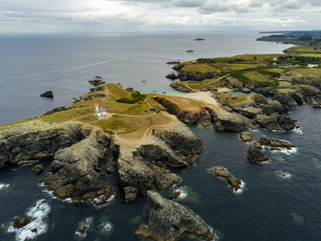 Aerial view of Pointe des Poulains with its iconic lighthouse rugged rocky coastline sandy beach and surrounding Atlantic Ocean in Sauzon Bretagne France. Aerial view of Pointe des Poulains with its iconic lighthouse rugged rocky coastline sandy beach and surrounding Atlantic Ocean in Sauzon Bretagne France.