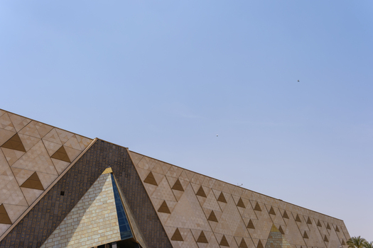 Giza Egypt 16 May 2026 View of the modern facade of the Grand Egyptian Museum featuring intricate triangular patterns under a clear blue sky.