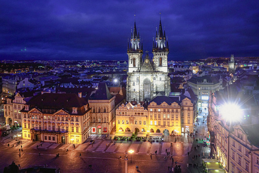 Aerial view of the Church of Our Lady before Tyn illuminated at night overlooking the historic Old Town Square with surrounding architecture in Prague Prague Czechia. Aerial view of the Church of Our Lady before Tyn illuminated at night overlooking the historic Old Town Square with surrounding architecture in Prague Prague Czechia.