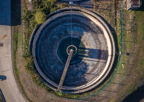 Aerial view of the circular sedimentation tank at the Water Treatment Centre Camberley with industrial infrastructure in Camberley England United Kingdom. Aerial view of the circular sedimentation tank at the Water Treatment Centre Camberley with industrial infrastructure in Camberley England United Kingdom.