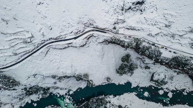 Aerial view of a winding road cutting through a snow laden landscape contrasting with the turquoise river flowing below Sharda Azad Kashmir Pakistan. Aerial view of a winding road cutting through a snow laden landscape contrasting with the turquoise river flowing below Sharda Azad Kashmir Pakistan.