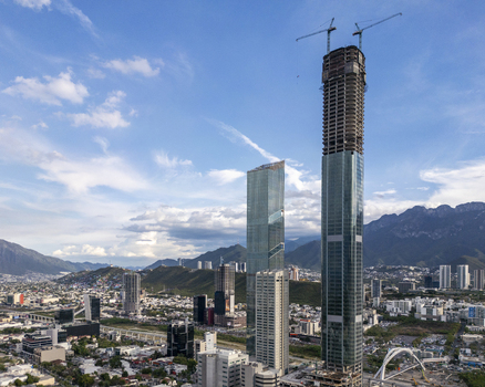 Aerial view of Rise Tower under construction with cranes surrounded by modern skyscrapers and the Sierra Madre Oriental mountains in Monterrey Nuevo Leon Mexico. Aerial view of Rise Tower under construction with cranes surrounded by modern skyscrapers and the Sierra Madre Oriental mountains in Monterrey Nuevo Leon Mexico.
