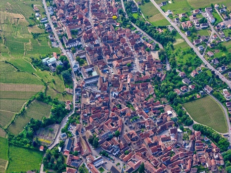 Aerial view of the historic town of Ribeauville with its dense red tiled rooftops surrounded by lush green vineyards and rolling hills in Ribeauville Grand Est France. Aerial view of the historic town of Ribeauville with its dense red tiled rooftops surrounded by lush green vineyards and rolling hills in Ribeauville Grand Est France.