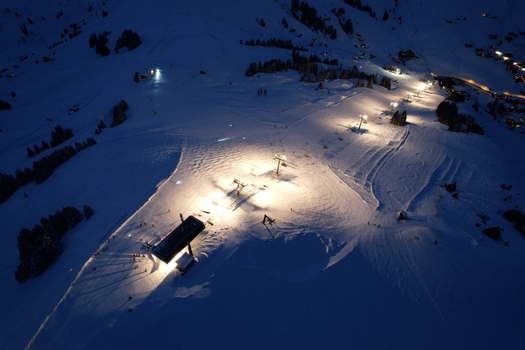 Aerial view of Les Crosets ski resort at night with illuminated ski slopes and chairlifts among the snow covered mountains in Val d Illiez Valais Switzerland. Aerial view of Les Crosets ski resort at night with illuminated ski slopes and chairlifts among the snow covered mountains in Val d Illiez Valais Switzerland.