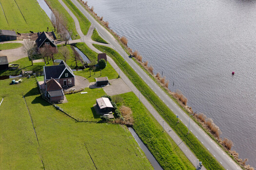 Aerial view of a tranquil Dutch landscape where a serene river meets lush green fields and quaint farmhouses Wormer Netherlands. Aerial view of a tranquil Dutch landscape where a serene river meets lush green fields and quaint farmhouses Wormer Netherlands.