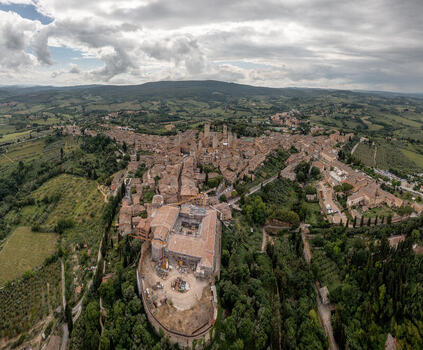 Aerial view of San Gimignano with its iconic medieval towers historic stone buildings and surrounding rolling hills of the Tuscan countryside in San Gimignano Tuscany Italy. Aerial view of San Gimignano with its iconic medieval towers historic stone buildings and surrounding rolling hills of the Tuscan countryside in San Gimignano Tuscany Italy.