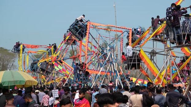 View of crowded fairground with manual Ferris wheels Bangladesh. View of crowded fairground with manual Ferris wheels Bangladesh.