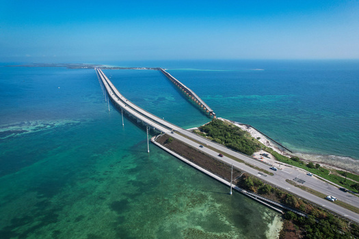 Aerial view of The Overseas Highway stretching across turquoise ocean waters under a clear blue sky Key Largo Florida United States. Aerial view of The Overseas Highway stretching across turquoise ocean waters under a clear blue sky Key Largo Florida United States.