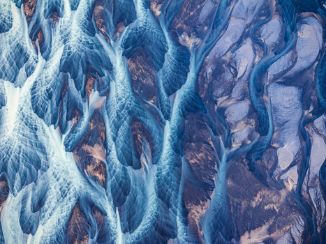 Aerial view of the intricate braided river patterns with glacial silt and dark volcanic sediment flowing through the landscape of Iceland. Aerial view of the intricate braided river patterns with glacial silt and dark volcanic sediment flowing through the landscape of Iceland.