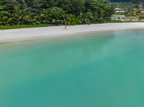 Aerial view of turquoise waters meet the pristine white sands fringed by verdant palms and lush greenery creating a serene coastal paradise Victoria Seychelles. Aerial view of turquoise waters meet the pristine white sands fringed by verdant palms and lush greenery creating a serene coastal paradise Victoria Seychelles.