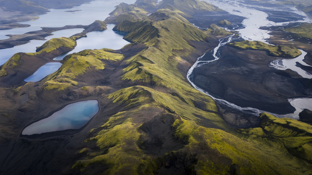 Aerial view of Langisjor lake surrounded by vibrant green moss covered volcanic mountains and winding glacial rivers in Skaftarhreppur Iceland. Aerial view of Langisjor lake surrounded by vibrant green moss covered volcanic mountains and winding glacial rivers in Skaftarhreppur Iceland.