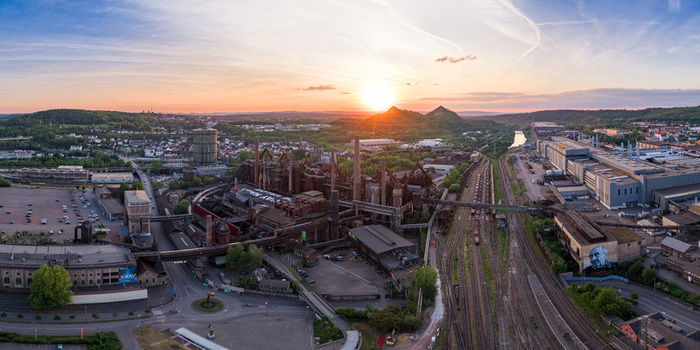 Volklingen Germany 09 May 2026 Aerial view of Volklingen Ironworks industrial complex with blast furnaces and railway tracks under a golden sunset sky. Volklingen Germany 09 May 2026 Aerial view of Volklingen Ironworks industrial complex with blast furnaces and railway tracks under a golden sunset sky.