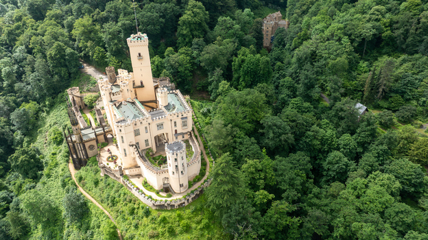 Aerial view of Stolzenfels Castle with its white towers and battlements surrounded by the lush green forest of the Rhine Valley in Koblenz Rheinland Pfalz Germany. Aerial view of Stolzenfels Castle with its white towers and battlements surrounded by the lush green forest of the Rhine Valley in Koblenz Rheinland Pfalz Germany.
