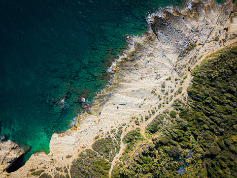 Aerial view of the rugged coastline where turquoise waters meet the pale stone cliffs and verdant forests creating a stunning contrast of nature s artistry Pula Istria County Croatia.