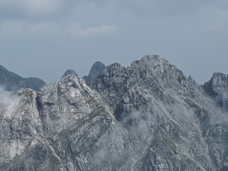Aerial view of the rugged marble peaks of the Apuan Alps featuring sharp rocky ridges steep slopes and wisps of clouds clinging to the mountainside Carrara Tuscany Italy. Aerial view of the rugged marble peaks of the Apuan Alps featuring sharp rocky ridges steep slopes and wisps of clouds clinging to the mountainside Carrara Tuscany Italy.