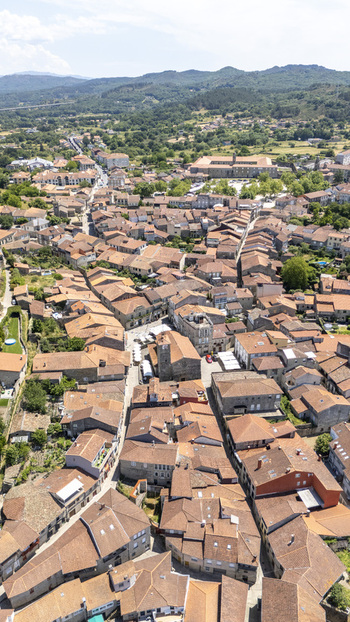Aerial view of the historic town of Allariz featuring dense terracotta tiled rooftops narrow stone streets and surrounding green hills in Allariz Province of Ourense Spain. Aerial view of the historic town of Allariz featuring dense terracotta tiled rooftops narrow stone streets and surrounding green hills in Allariz Province of Ourense Spain.