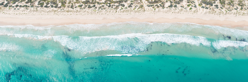 Aerial view of the coastline with turquoise waves crashing onto the sandy beach and dunes in Perth Western Australia Australia. Aerial view of the coastline with turquoise waves crashing onto the sandy beach and dunes in Perth Western Australia Australia.