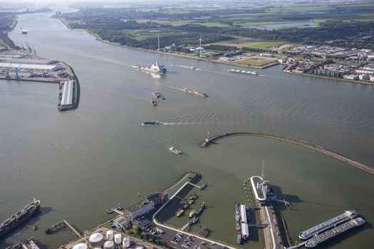 Rotterdam South Holland Netherlands 03 September 2014 Aerial view of Rotterdam Harbour with cargo ships navigating the waterway surrounded by industrial infrastructure and green landscapes. Rotterdam South Holland Netherlands 03 September 2014 Aerial view of Rotterdam Harbour with cargo ships navigating the waterway surrounded by industrial infrastructure and green landscapes.