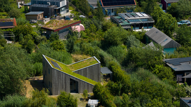Aerial view of Ecodorp Bolderburen featuring sustainable modern houses with green roofs wooden facades and solar panels nestled within lush greenery in Almere Flevoland Netherlands. Aerial view of Ecodorp Bolderburen featuring sustainable modern houses with green roofs wooden facades and solar panels nestled within lush greenery in Almere Flevoland Netherlands.