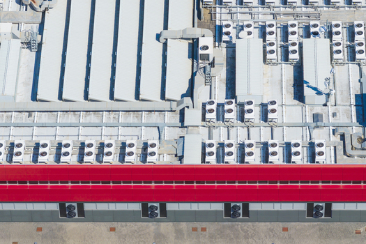 Aerial view of the industrial roof of a datacenter featuring numerous HVAC cooling units and a distinctive red trim in Arezzo Tuscany Italy. Aerial view of the industrial roof of a datacenter featuring numerous HVAC cooling units and a distinctive red trim in Arezzo Tuscany Italy.