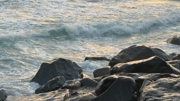 View of ocean waves crashing against rocks at sunset United States. View of ocean waves crashing against rocks at sunset United States.