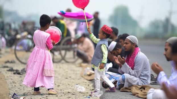 View of children with balloons and men praying during Eid Bangladesh. View of children with balloons and men praying during Eid Bangladesh.