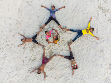 Alakjhari Bangladesh 26 July 2026 Aerial view of children lying on the sandy ground in a star formation at Jharbari ghat under bright daylight.