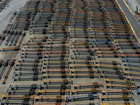 Aerial view of a large industrial storage yard filled with rows of colorful semi trailer chassis parked in an organized grid in Carson California United States.