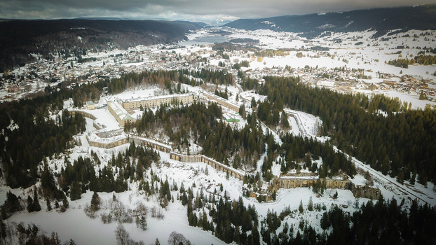 Aerial view of Le Fort des Rousses surrounded by snow covered pine forests and the winter landscape of Les Rousses Bourgogne Franche Comte France.