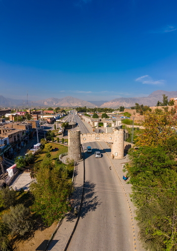 Aerial view of the historic stone archway at the Khyber Pass with vehicles on the road and mountains in the background in Khyber District Khyber Pakhtunkhwa Pakistan. Aerial view of the historic stone archway at the Khyber Pass with vehicles on the road and mountains in the background in Khyber District Khyber Pakhtunkhwa Pakistan.