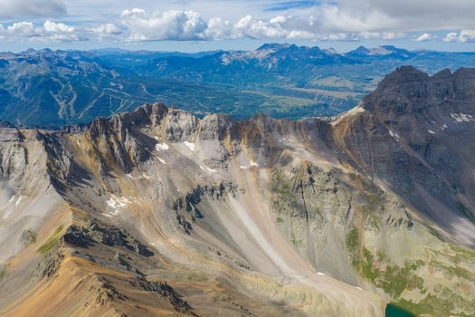 Aerial view of Mount Sneffels in the San Juan Mountains featuring rugged rocky peaks steep slopes and alpine terrain in the Yankee Boy Basin area of Ouray County Colorado United States. Aerial view of Mount Sneffels in the San Juan Mountains featuring rugged rocky peaks steep slopes and alpine terrain in the Yankee Boy Basin area of Ouray County Colorado United States.