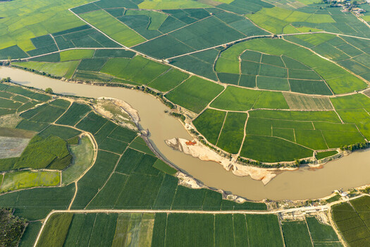 Aerial view of Lak Lake surrounded by vibrant green rice fields and a winding river in the rural landscape of Lien Son Lak Dak Lak Vietnam. Aerial view of Lak Lake surrounded by vibrant green rice fields and a winding river in the rural landscape of Lien Son Lak Dak Lak Vietnam.
