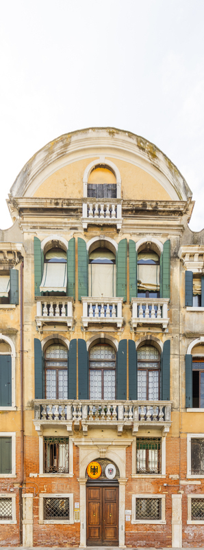 View of the historic facade of the German Consulate in Venice with arched windows green shutters stone balconies and ornate architectural details in Venice Veneto Italy. View of the historic facade of the German Consulate in Venice with arched windows green shutters stone balconies and ornate architectural details in Venice Veneto Italy.