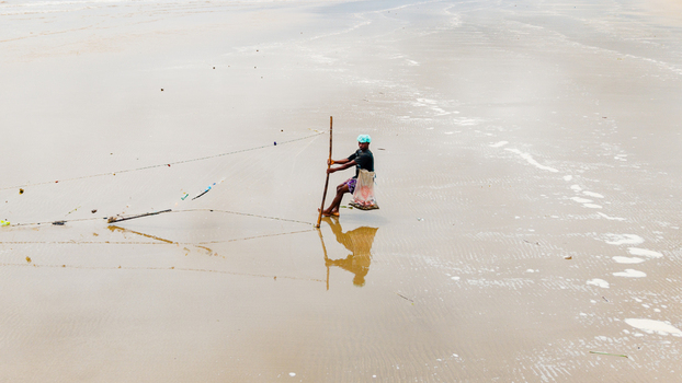 Aerial view of a fisherman using a traditional net on the wet sands of Ibeno Beach in Kwa Ibo Akwa Ibom Nigeria.