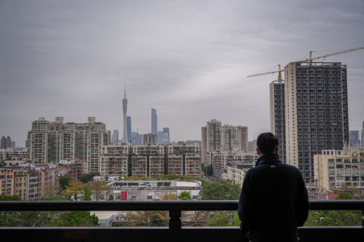 Guangzhou Guangdong Province China 23 February 2024 View of a person looking at the Guangzhou skyline featuring the Canton Tower rising above residential buildings and cranes. Guangzhou Guangdong Province China 23 February 2024 View of a person looking at the Guangzhou skyline featuring the Canton Tower rising above residential buildings and cranes.