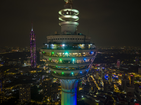 Kuala Lumpur Malaysia 11 March 2026 Aerial view of the Kuala Lumpur Tower illuminated with colorful lights against the night city skyline and Merdeka 118.