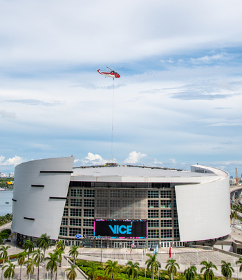 Miami Florida United States 22 September 2026 Aerial view of Kaseya Center with a helicopter performing a lift above the arena roof surrounded by palm trees and urban waterfront.
